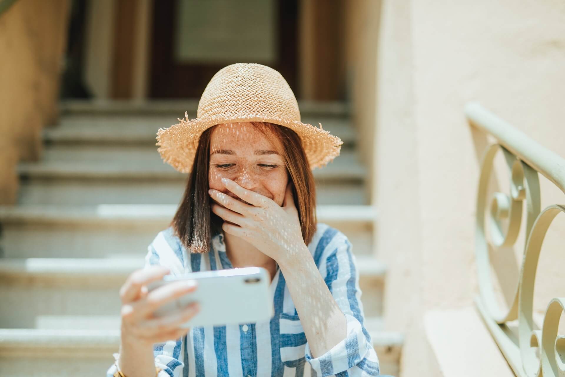 Woman smiling while making donation to nonprofit on her smartphone