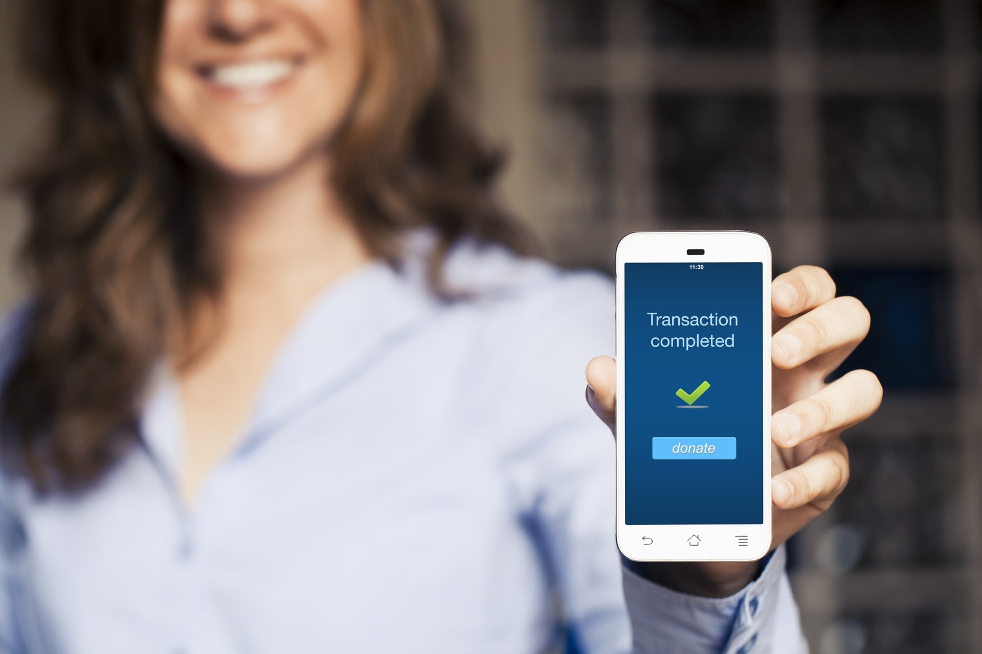Woman holding smartphone with donation transaction message