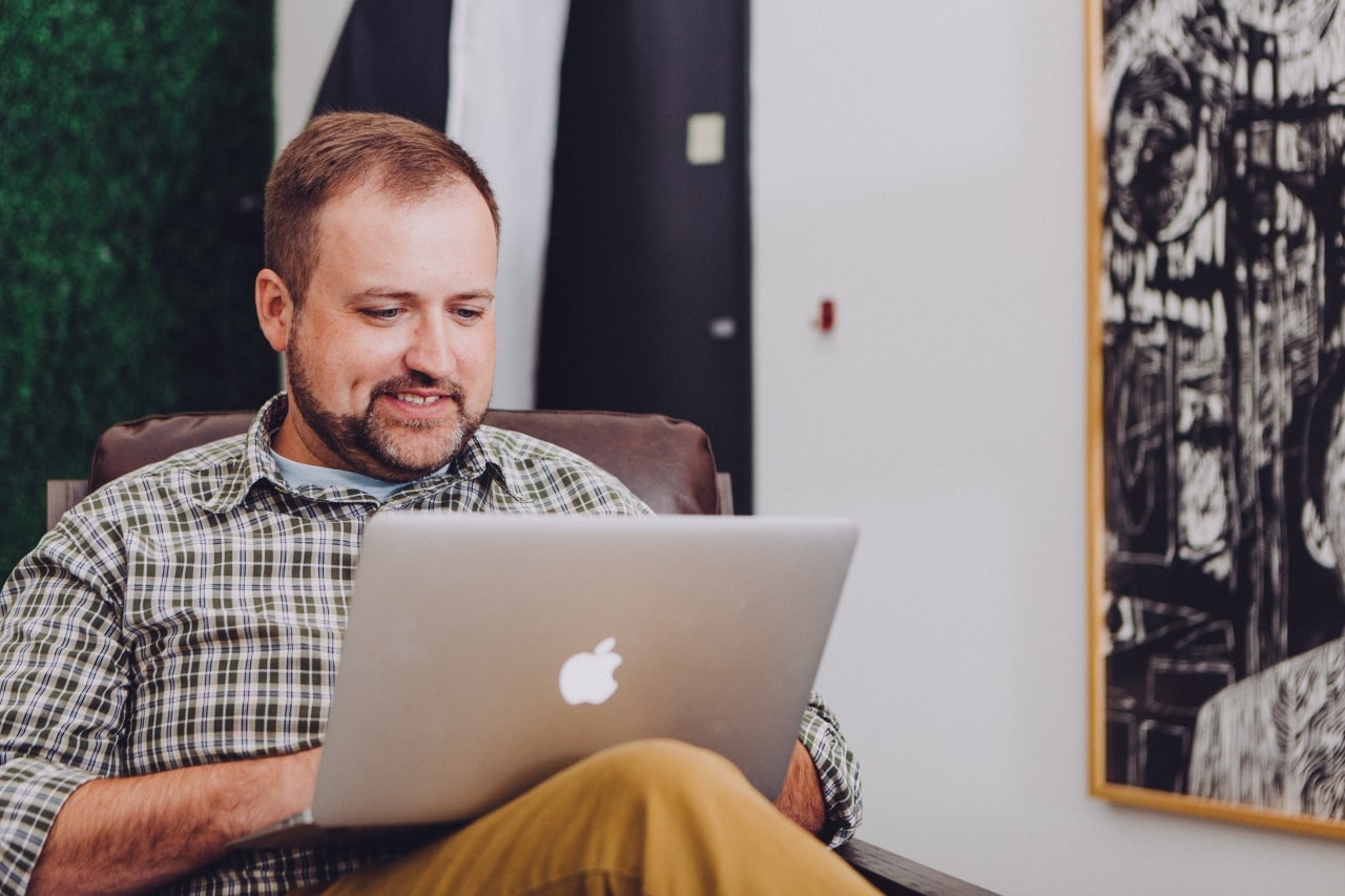 Smiling man using laptop computer